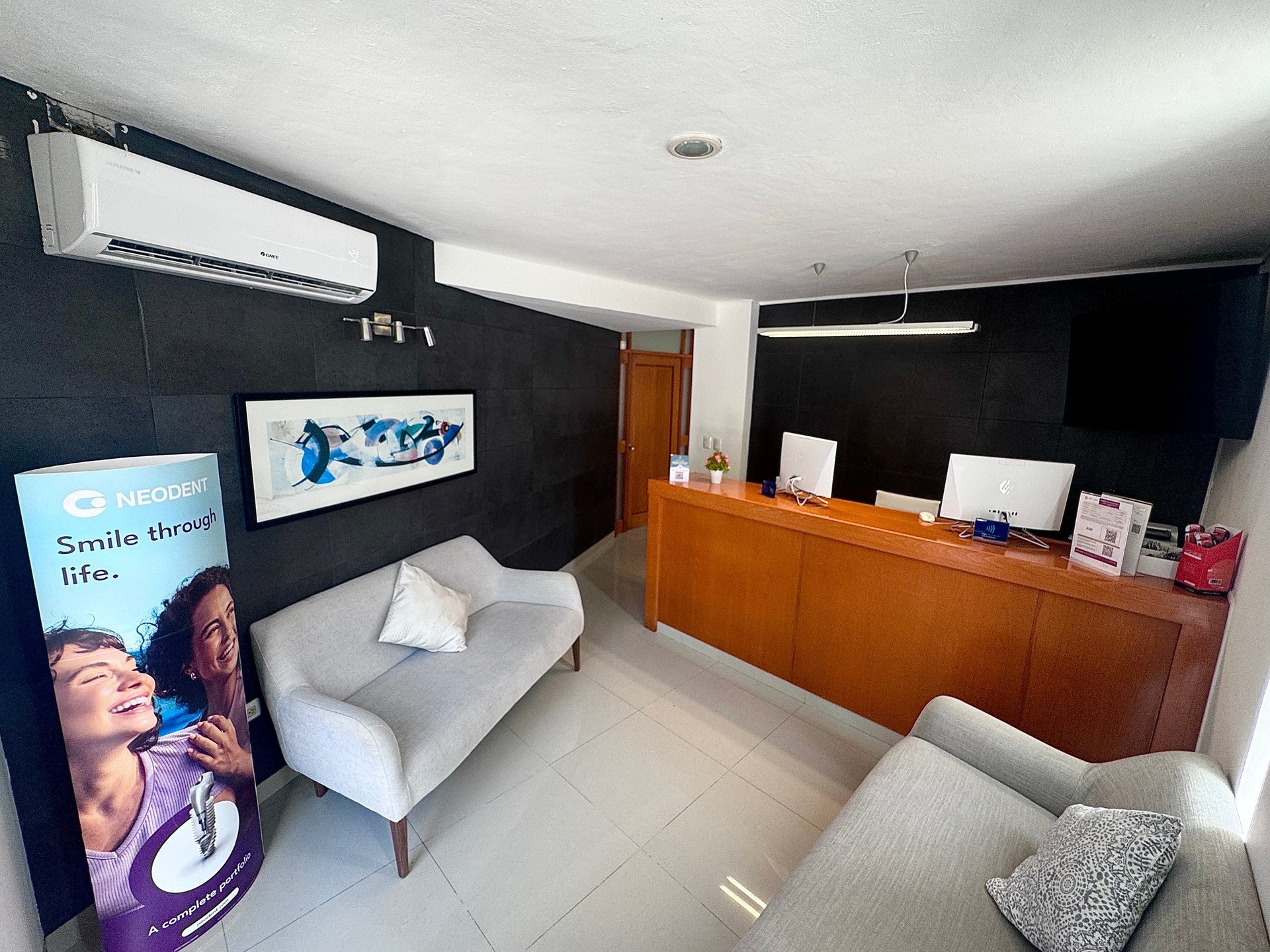 Modern dental clinic waiting room with black walls, white armchair, wooden reception desk, and minimalist decor